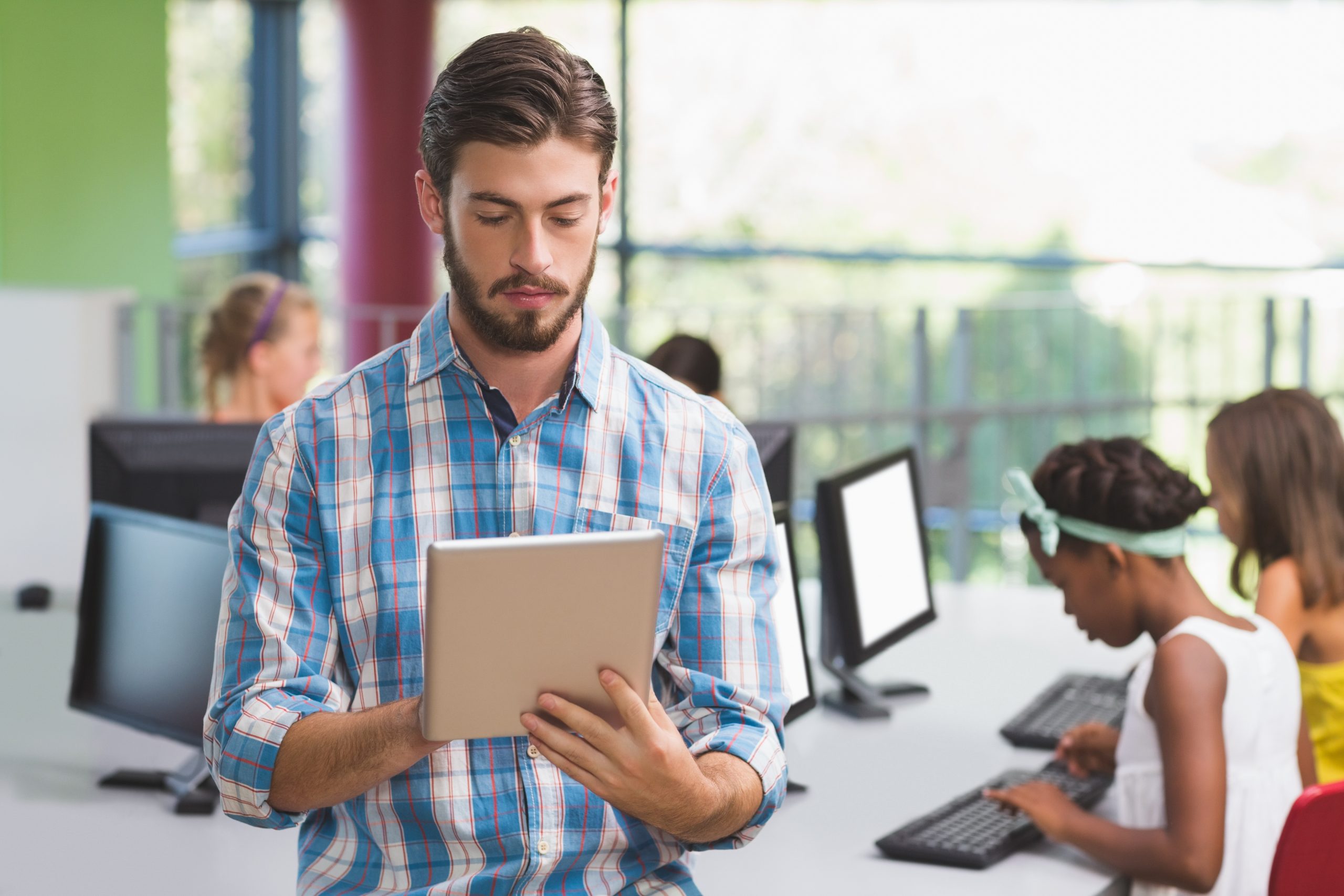Teacher using digital tablet in classroom